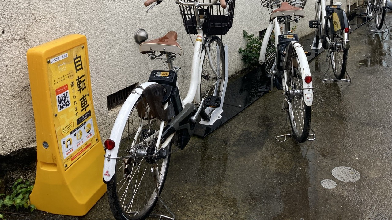 しずの湯の入口脇にあるHELLO CYCLINGのシェアサイクルのステーションと自転車