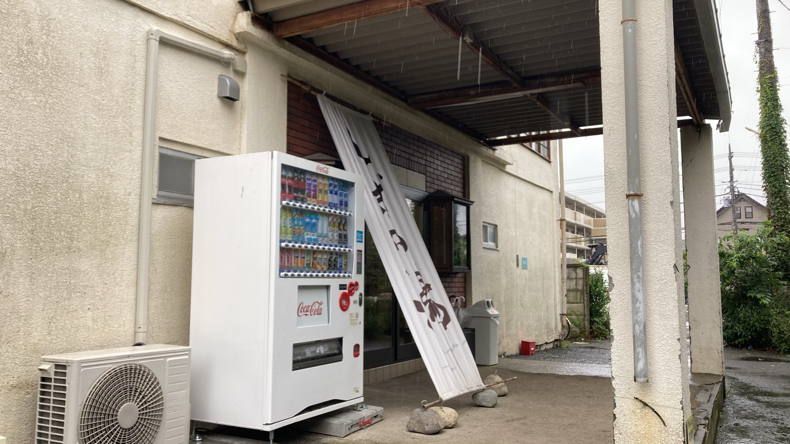 しずの湯の入口の軒下と自販機